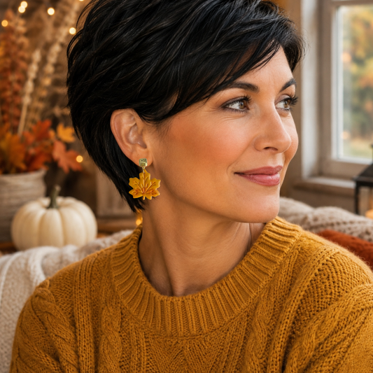 Model wearing mustard polymer clay maple leaf earrings with embossed vein details and polished gold-tone posts.