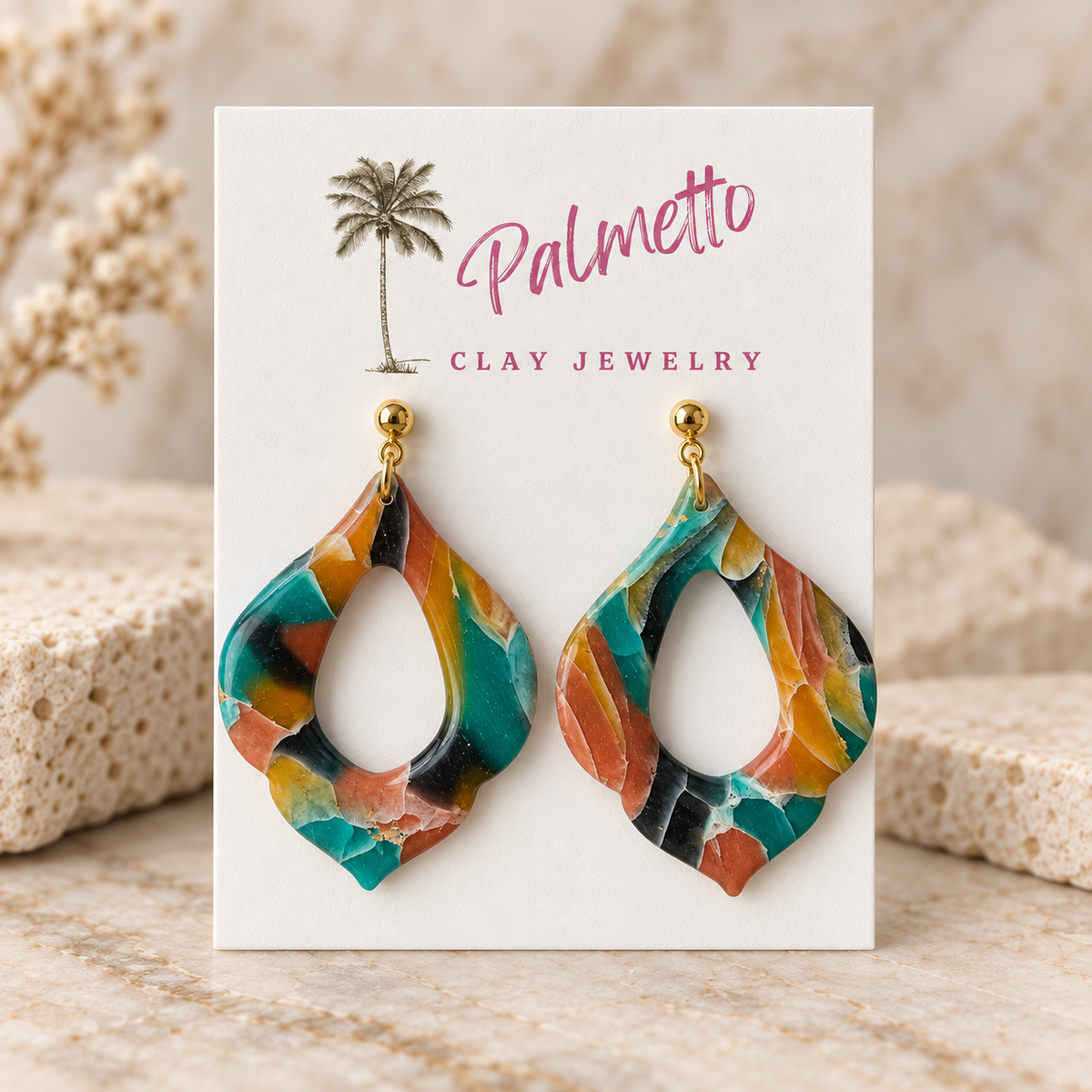 Colorful marbled polymer clay earrings in an open teardrop shape with turquoise, coral, mustard, black, and cream tones on gold-tone posts.