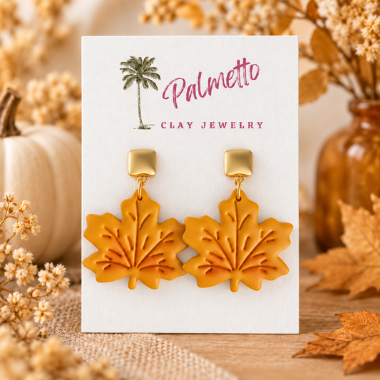 Mustard polymer clay maple leaf earrings with embossed vein details and polished gold-tone posts.